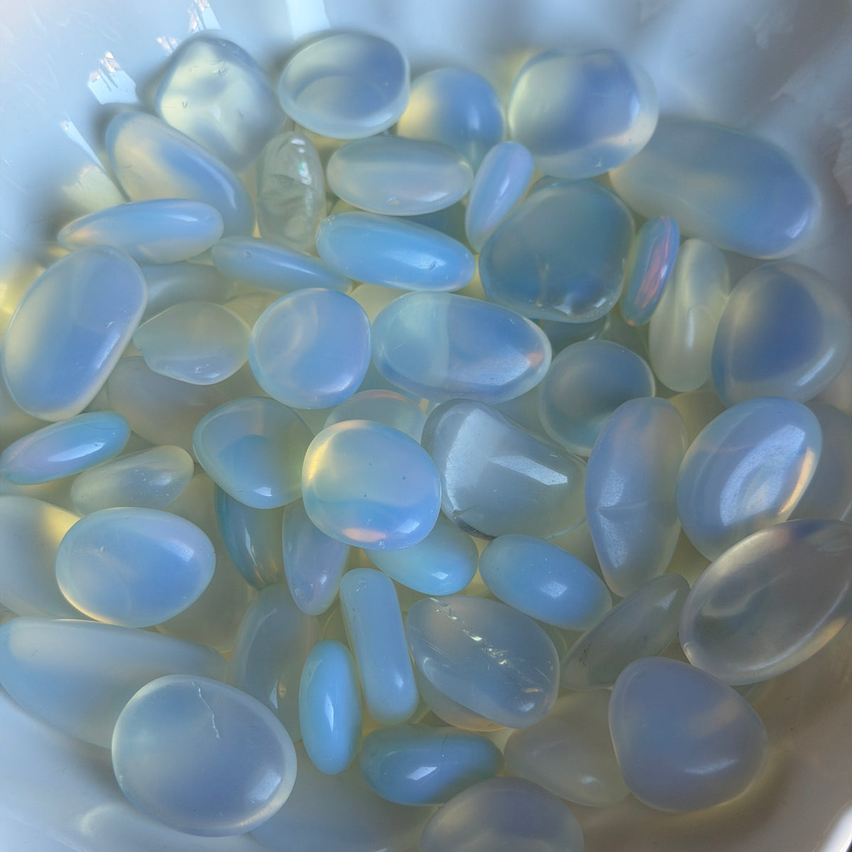 Opalite tumbled pocket stone crystal specimen with iridescent blue and white glow