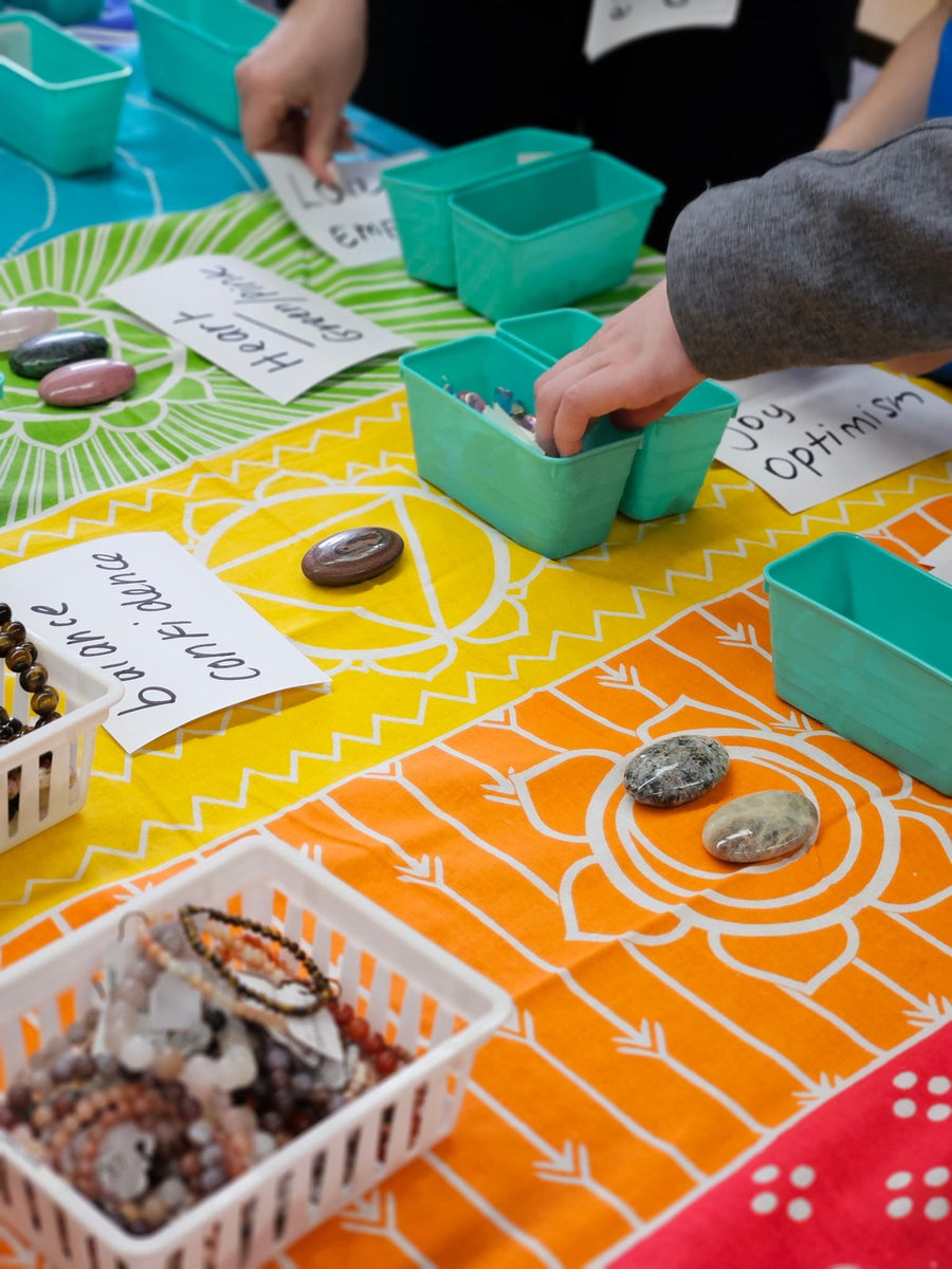 Guests picking tumbled stones from bins labelled with each stone's meaning