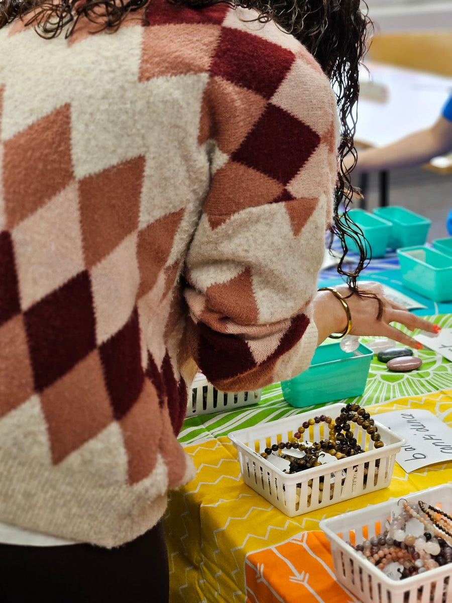 Workshop guest selecting a crystal from the chakra table